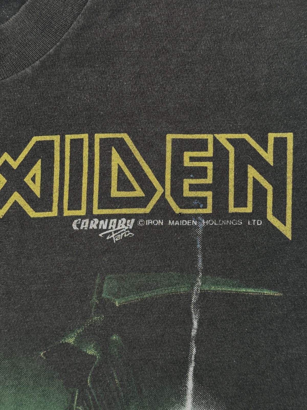 Makroaufnahme des originalen Copyright-Vermerks „© IRON MAIDEN HOLDINGS LTD“ und des „CARNABY“ Logos unter dem gelben Print als eindeutiger Echtheitsnachweis für das Shirt von 1988.