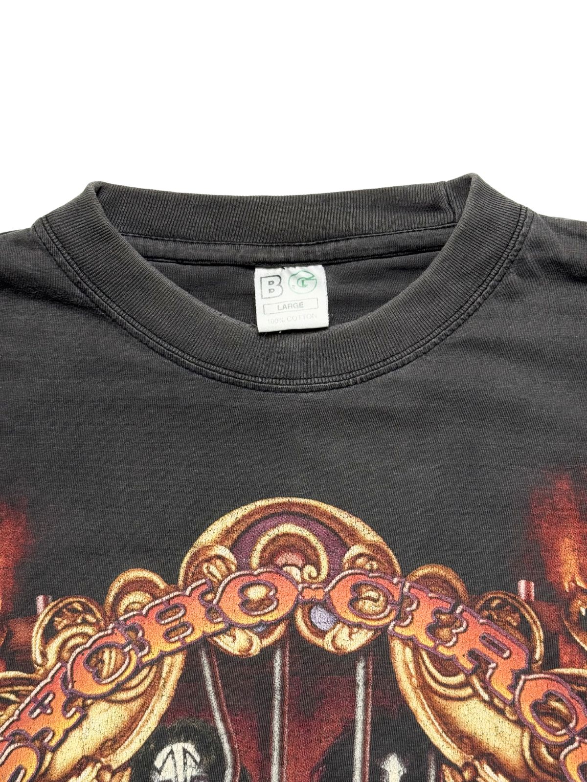 Detailansicht des Kragens mit dem originalen, eingenähten weißen Nackenetikett der Marke „BG“ (Größe Large, 100% Cotton) oberhalb des Bogen-Schriftzugs „PSYCHO CIRCUS“.
