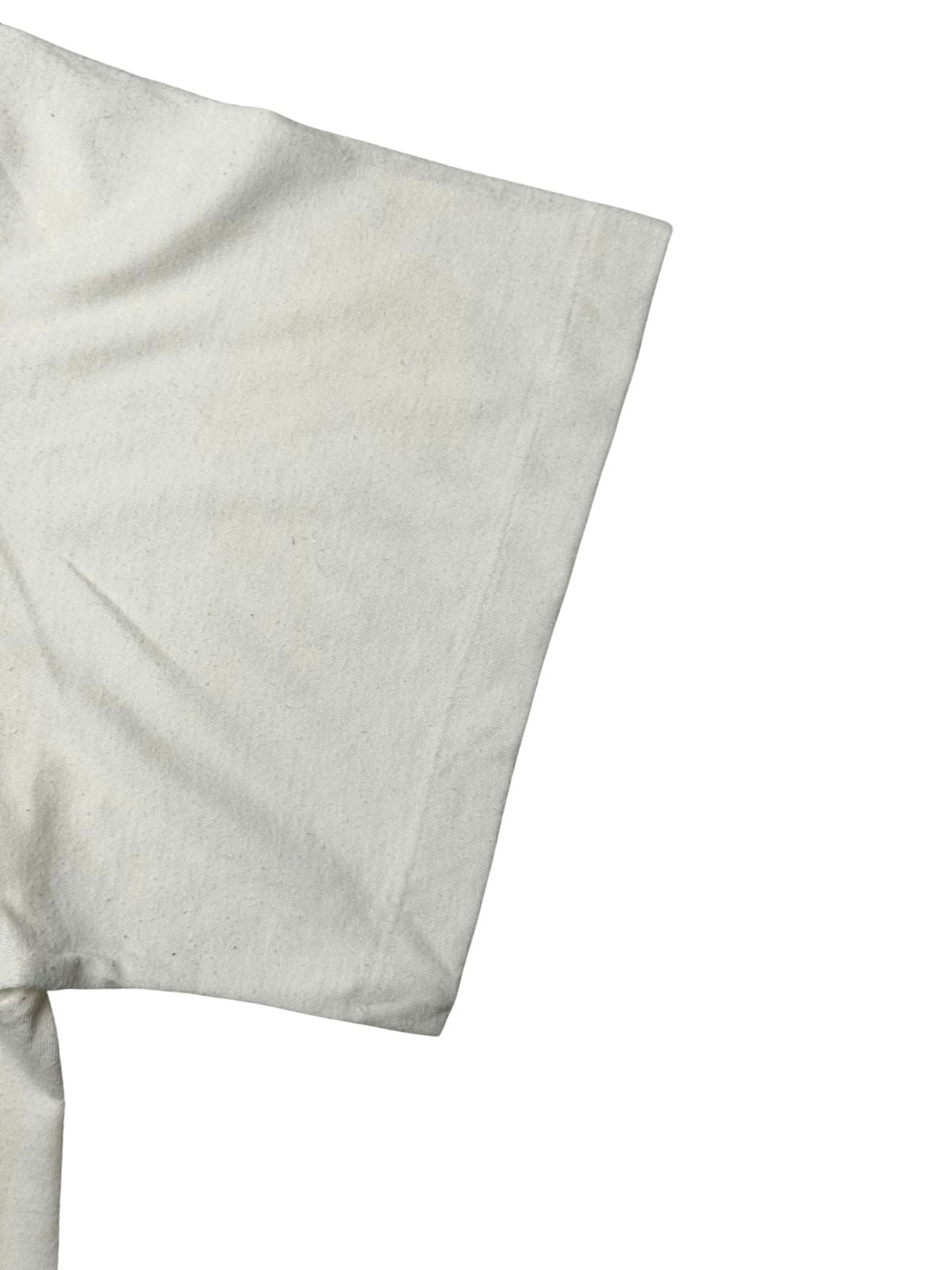 Detailansicht des Ärmels mit echter Vintage-Single-Stitch-Einfachnaht am Ärmelbund auf cremeweißem Baumwollstoff.