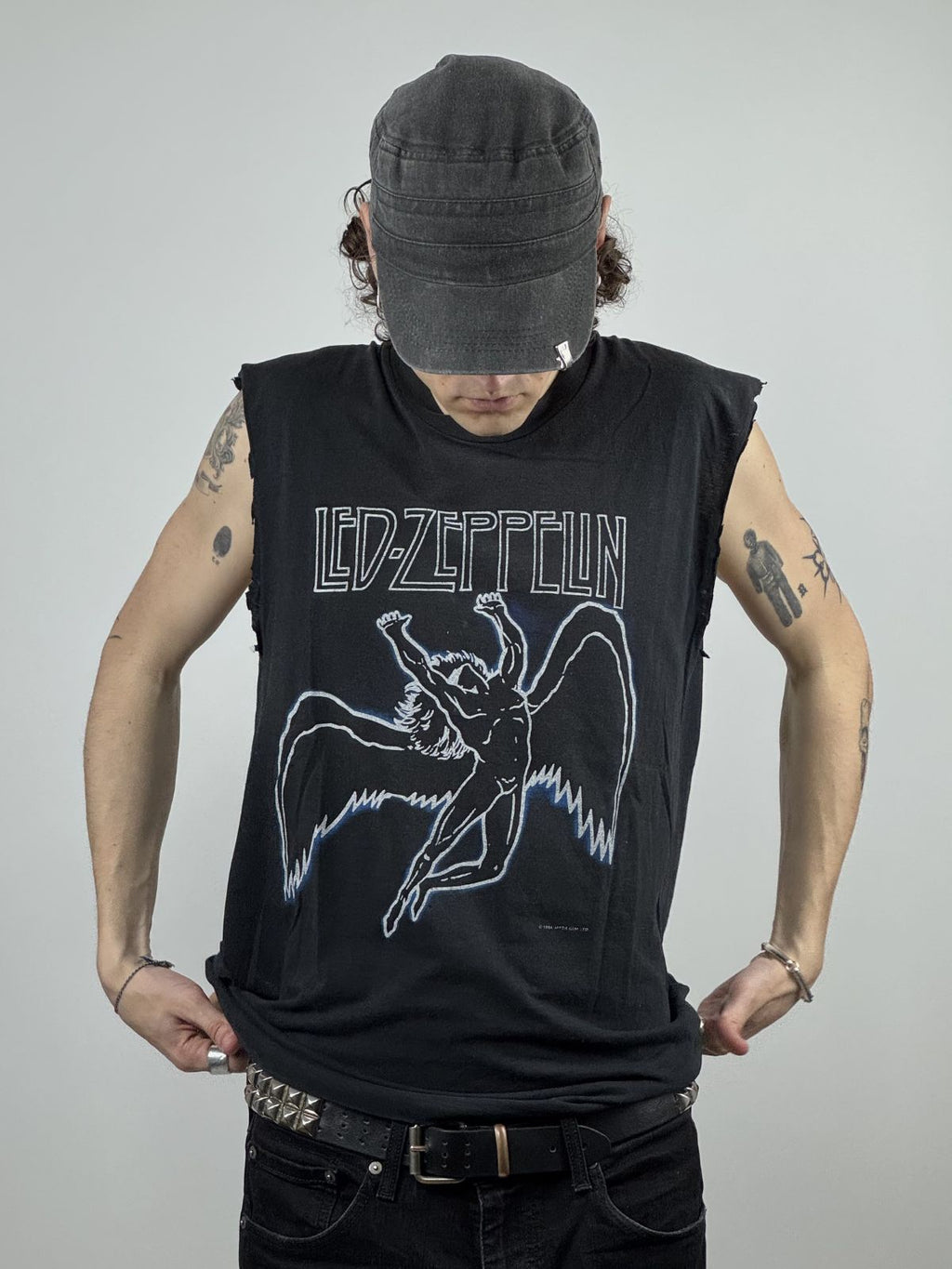 Ein Model trägt das Led Zeppelin Icarus Tank Top von 1984; zeigt die lockere Passform und die tief ausgeschnittenen Armlöcher im Rock-Stil.