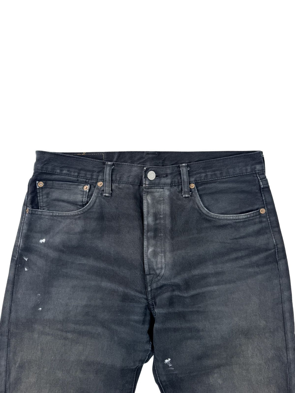 Nahaufnahme des Hosenbundes der schwarzen Levi's; zeigt den metallischen Hauptknopf, die Knopfleiste und markante Sun-Fade-Effekte im Hüftbereich.