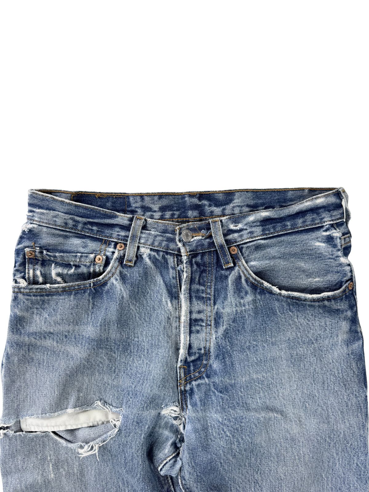 Nahaufnahme des Hosenbundes und der vorderen Taschen; zeigt extremes Fraying (Ausfransen) an den Kanten und die Textur des gealterten Denims.