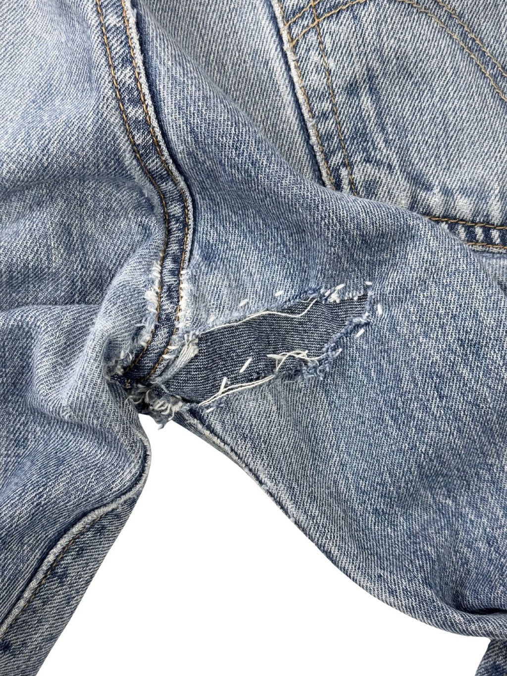 Rückansicht der Reparaturstelle im Schritt; verdeutlicht die robuste, handgefertigte Nahtführung, die den thrashed Look der Vintage-Hose verstärkt.