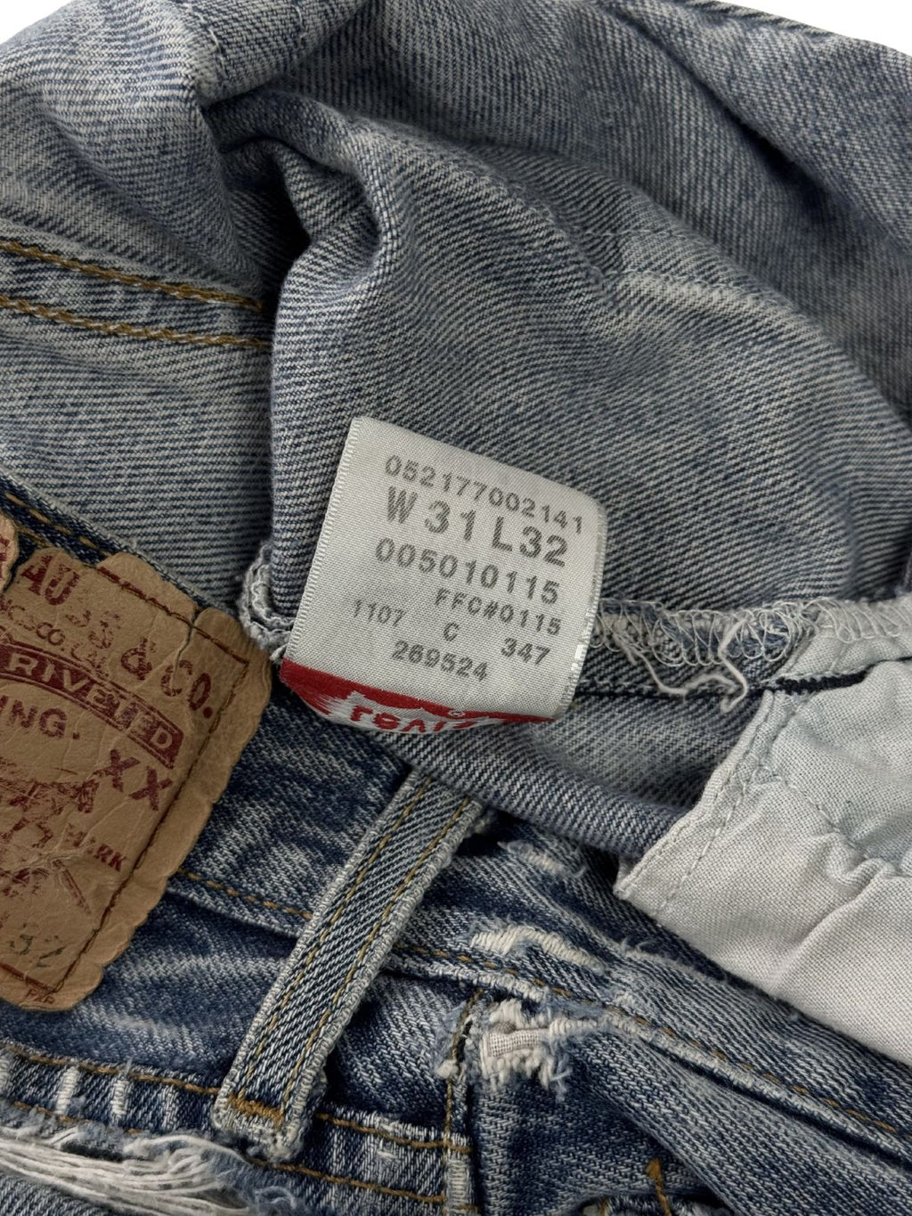 Detailansicht des inneren Pflegeetiketts; zeigt die verwaschenen Größenangaben und Herstellungsdetails der originalen Levi's 501 Jeans.