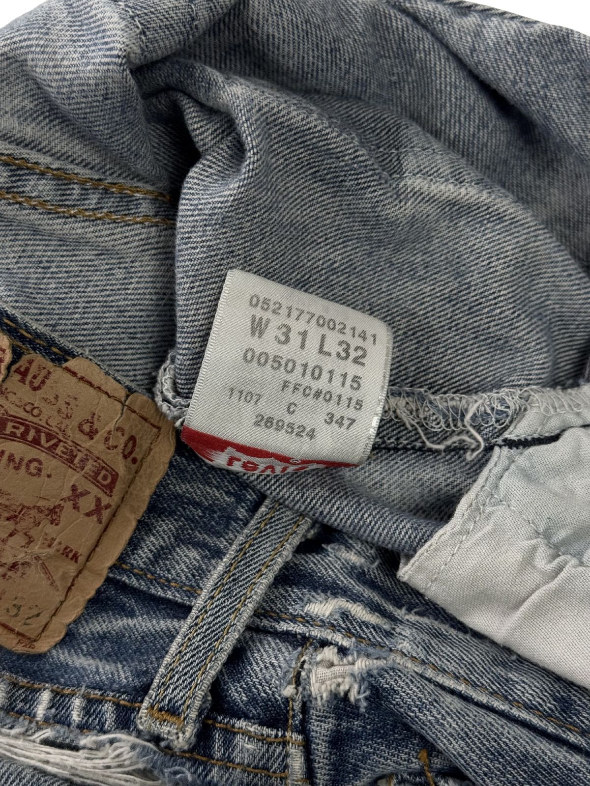 Detailansicht des inneren Pflegeetiketts; zeigt die verwaschenen Größenangaben und Herstellungsdetails der originalen Levi's 501 Jeans.