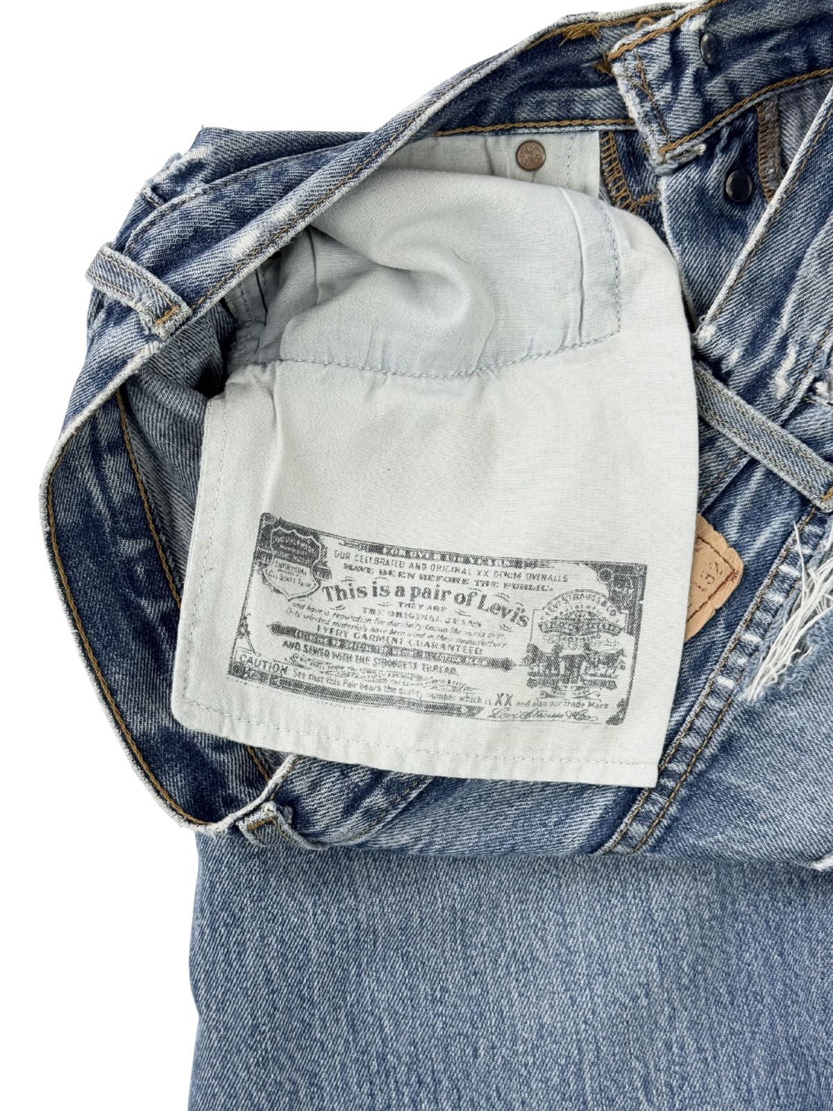 Blick auf die Innenseite der Jeans; zeigt das bedruckte Taschenfutter mit der historischen Levi's Garantieerklärung ("This is a pair of Levi's").