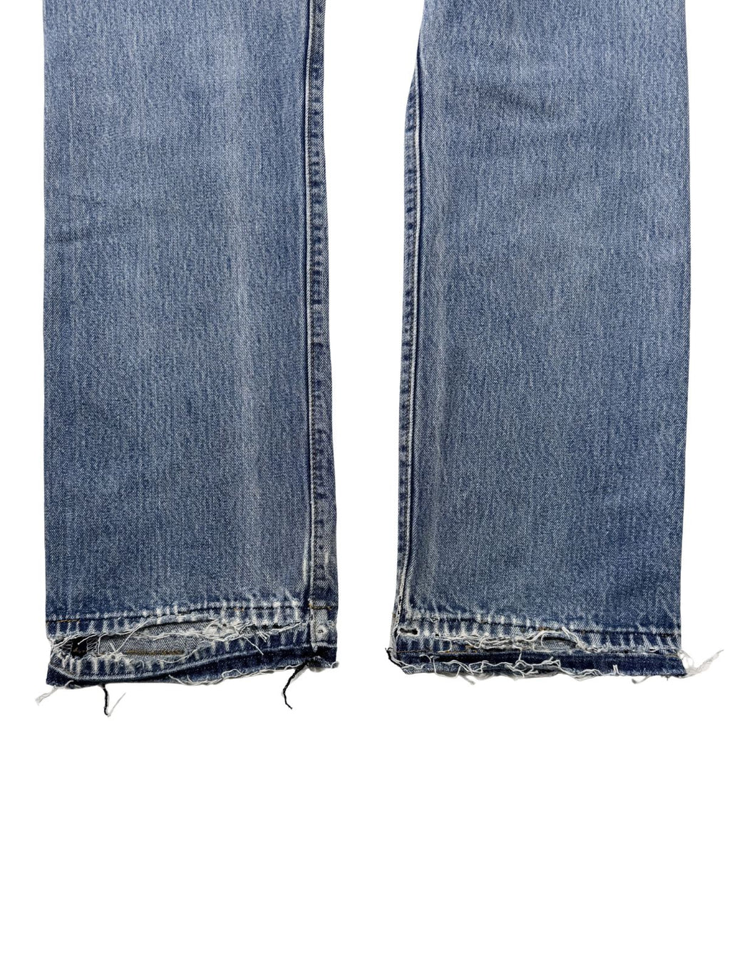 Detailaufnahme der Beinabschlüsse; zeigt extremes Ausfransen und Zerstörungen am Saum (sogenannte Heel Bites), typisch für lange getragene Vintage-Jeans.