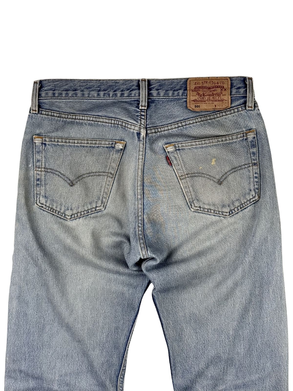 Nahaufnahme der hinteren Bund- und Gesäßpartie der Levi's 501 Jeans mit den markanten geschwungenen Ziernähten (Arcuate) auf den Taschen.