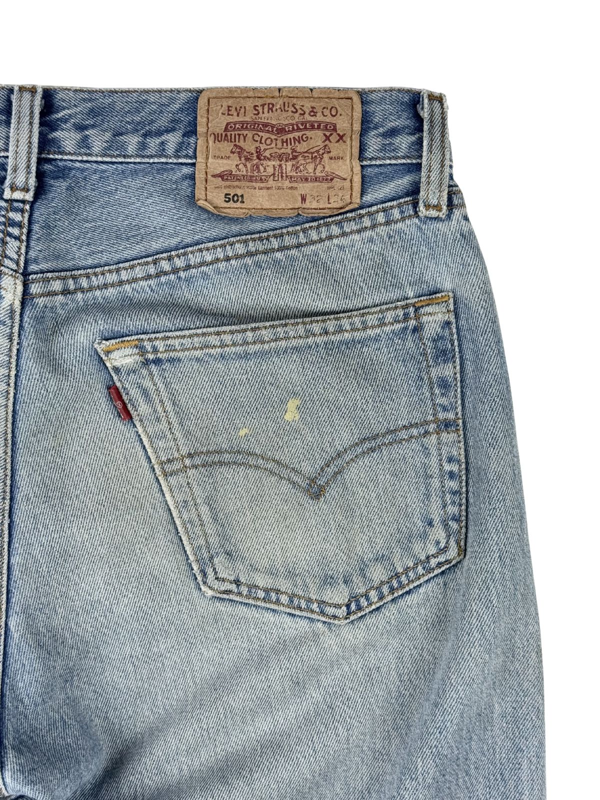 Nahaufnahme der hinteren rechten Gesäßtasche mit dem roten Levi's Stofffähnchen (Red Tab) und zwei kleinen, authentischen Flecken.