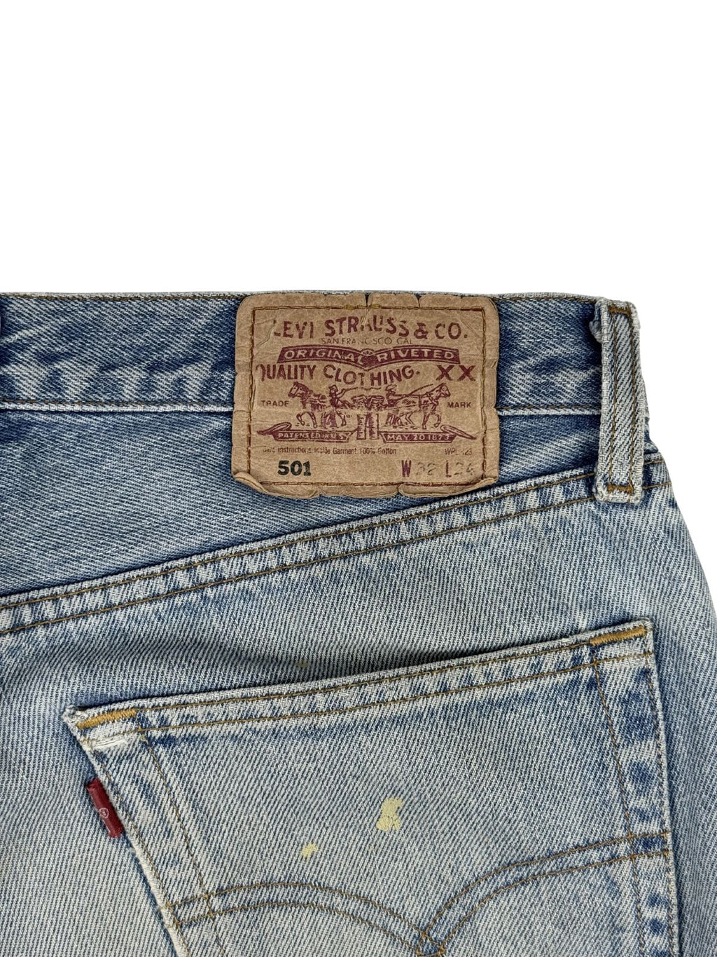 Detailansicht des originalen, braunen Levi Strauss & Co. Leder-Patches (Two Horse Patch) am Bund mit den Angaben „501 W32 L34“ sowie kleinen Farbflecken auf der rechten Tasche.