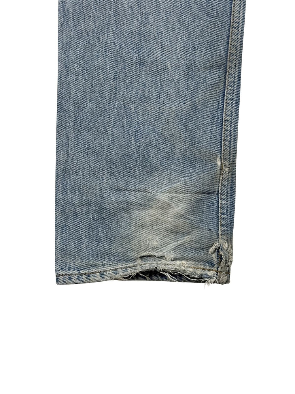 Detailaufnahme des hinteren linken Hosensaums mit starkem „Heel Bite“ (Abnutzung durch das Treten auf den Saum beim Gehen), ausgefransten Fäden und authentischem Thrashed-Look.