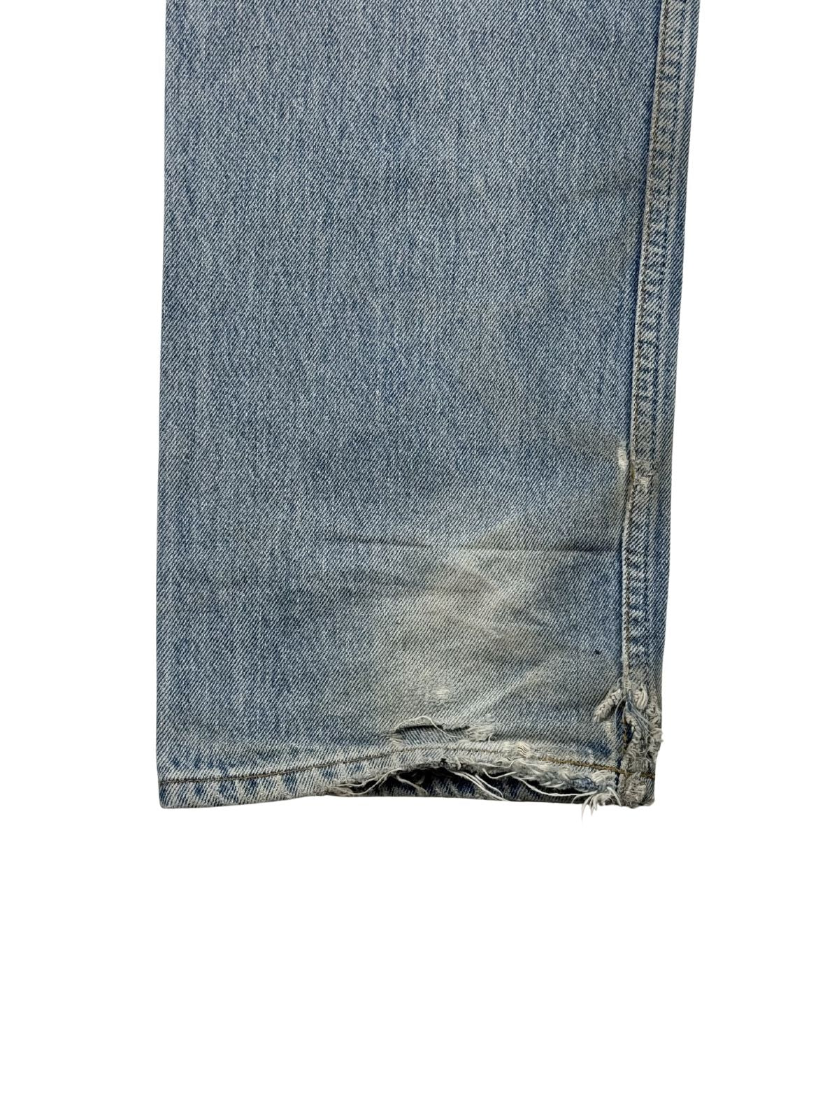 Detailaufnahme des hinteren linken Hosensaums mit starkem „Heel Bite“ (Abnutzung durch das Treten auf den Saum beim Gehen), ausgefransten Fäden und authentischem Thrashed-Look.