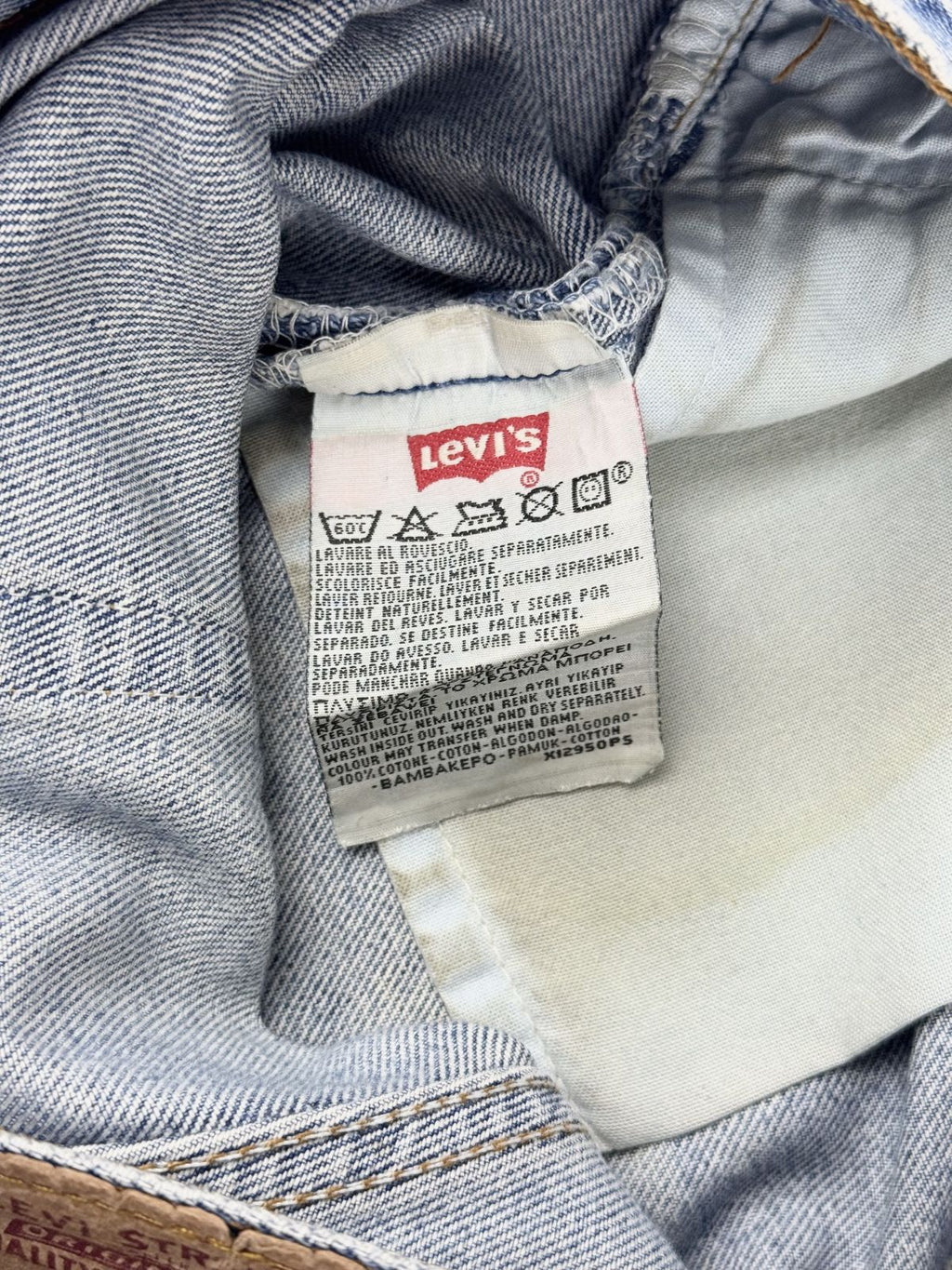 Nahaufnahme der Rückseite des inneren Levi's Etiketts mit den Pflegehinweisen in mehreren Sprachen und dem klassischen roten Levi's Logo.