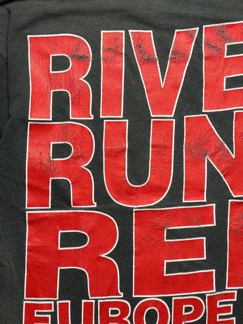 Detailansicht des leicht rissigen, authentisch gealterten Siebdrucks mit dem „RIVER RUNS RED“-Schriftzug auf dem Rücken.