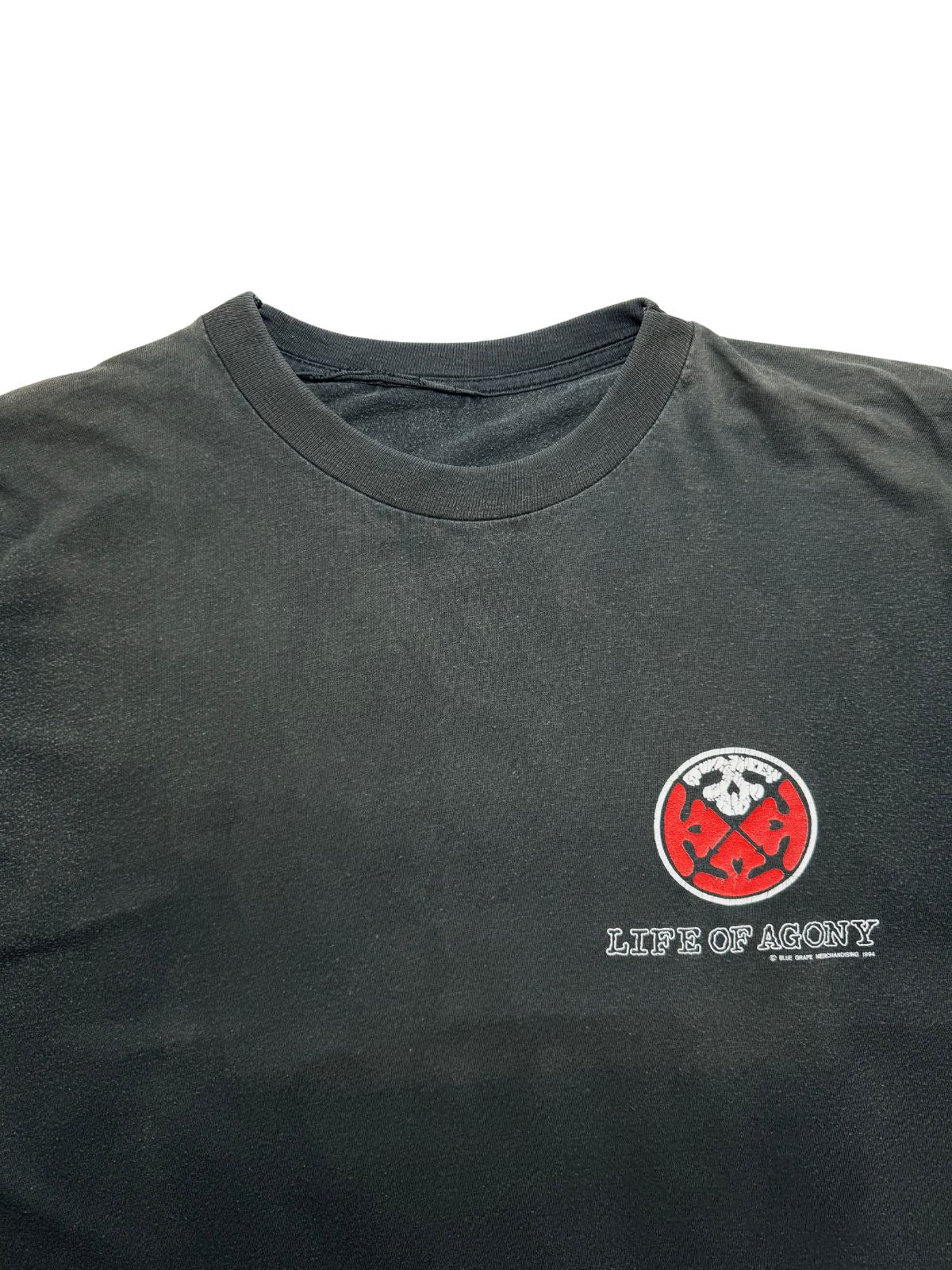 Detailansicht der oberen Frontpartie mit dem gerippten Rundhalsausschnitt und dem kleinen, runden Totenkopf-Logo nebst „LIFE OF AGONY“-Schriftzug.