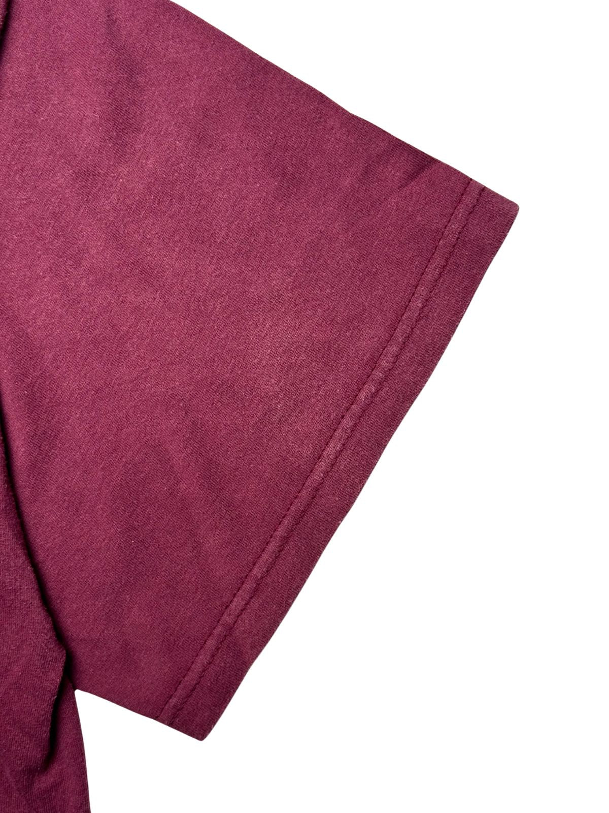 Detailansicht des kurzen Ärmels mit sauberer Doppelnaht am Ärmelbund auf dem maroon-farbenen Stoff.