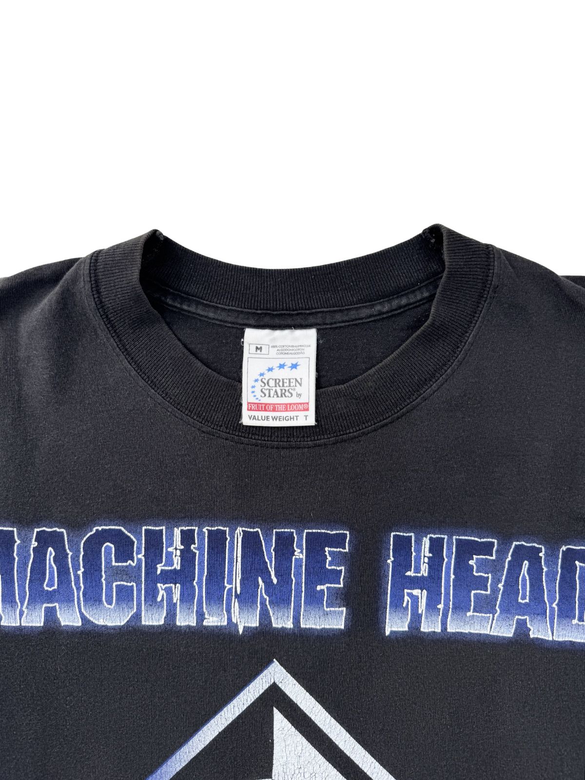 Nahaufnahme des Nackenetiketts: Weißes „Screen Stars by Fruit of the Loom Value Weight“ Tag, Größe M, in einem schwarzen Rundhals-T-Shirt.