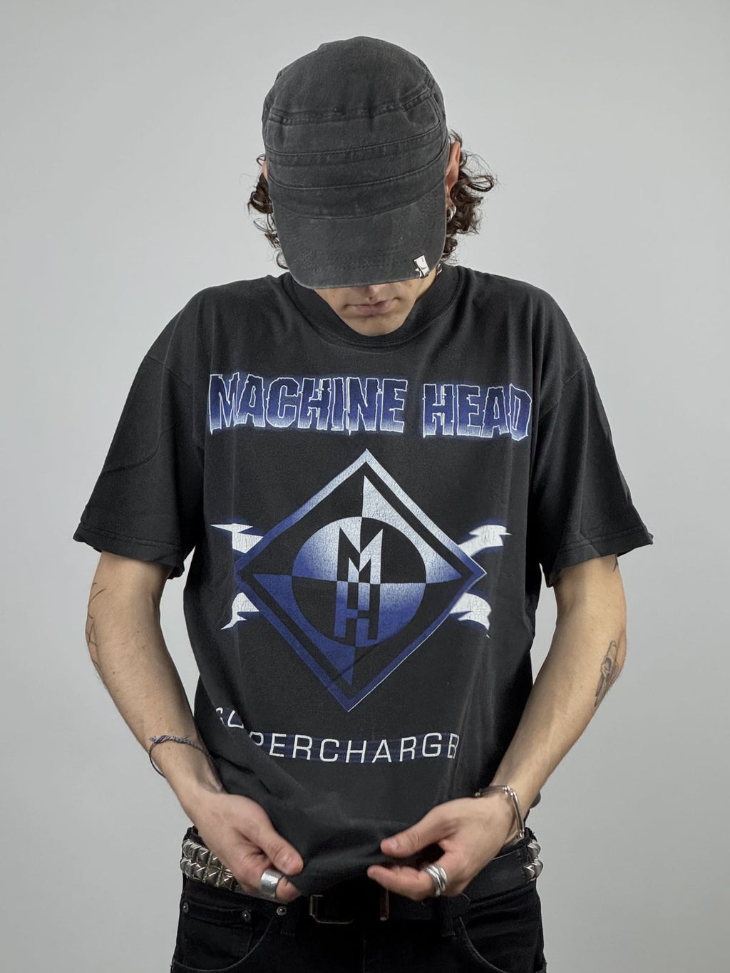 Nahaufnahme der Vorderansicht eines getragenen Machine Head Supercharger Shirts; Fokus auf dem blauen Diamond-Logo und dem Albumtitel.