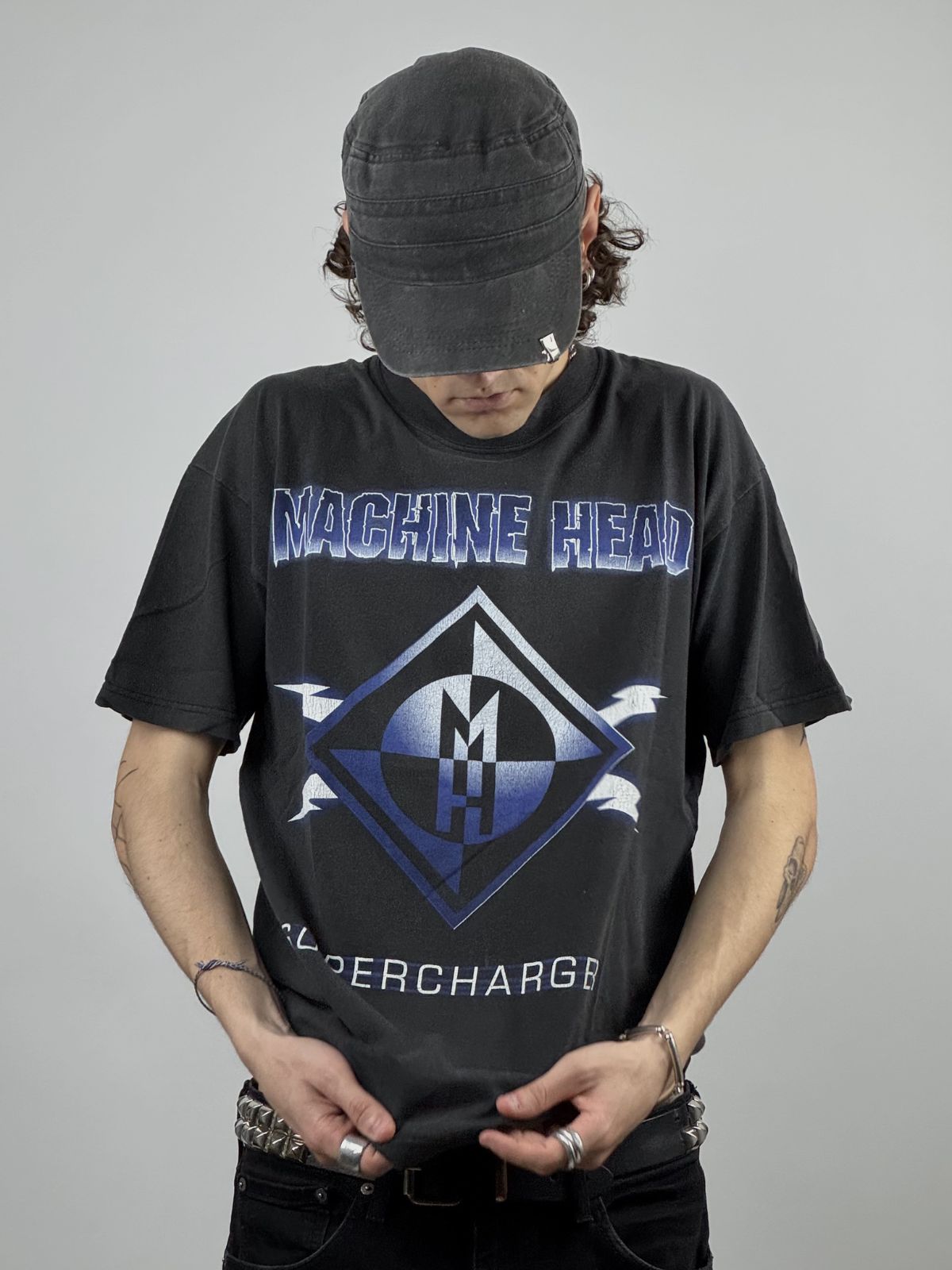 Nahaufnahme der Vorderansicht eines getragenen Machine Head Supercharger Shirts; Fokus auf dem blauen Diamond-Logo und dem Albumtitel.