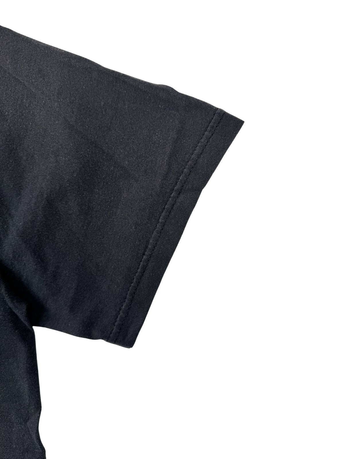 Detailaufnahme des Ärmelsaums mit Doppelnaht-Verarbeitung (Double Stitch) eines verwaschenen schwarzen Vintage-T-Shirts.