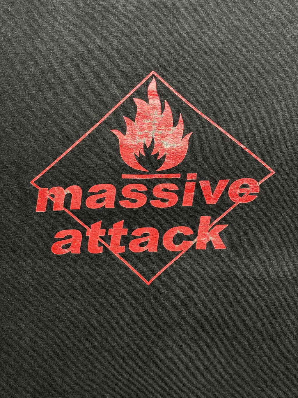 Detailansicht des vorderen Siebdrucks mit dem roten „massive attack“-Schriftzug und dem Flammen-Symbol in einer Raute im Used-Look.