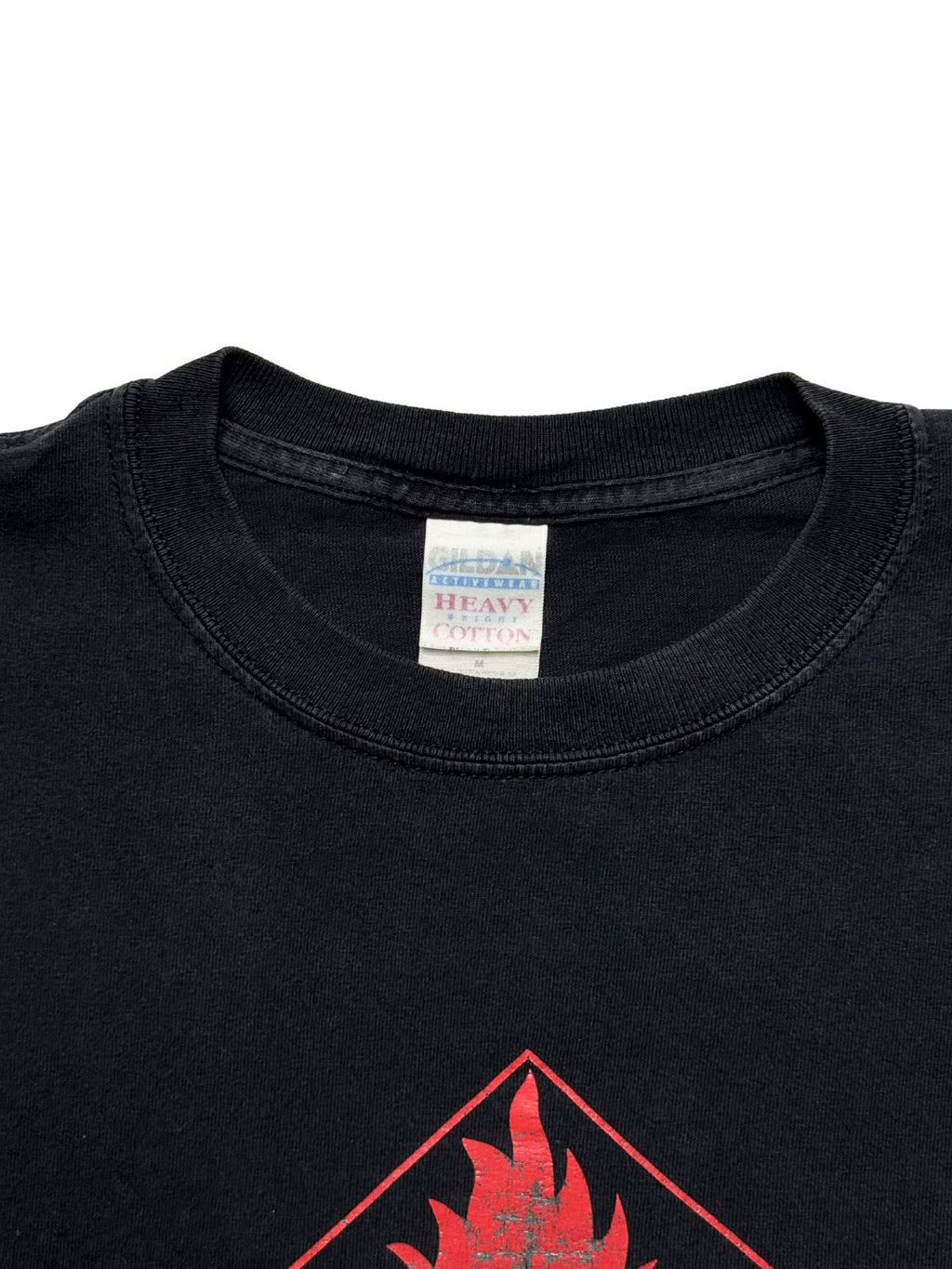 Nahaufnahme des Kragens mit dem originalen, leicht verwaschenen „Gildan Activewear Heavy Cotton“ Stoffetikett in Größe M.