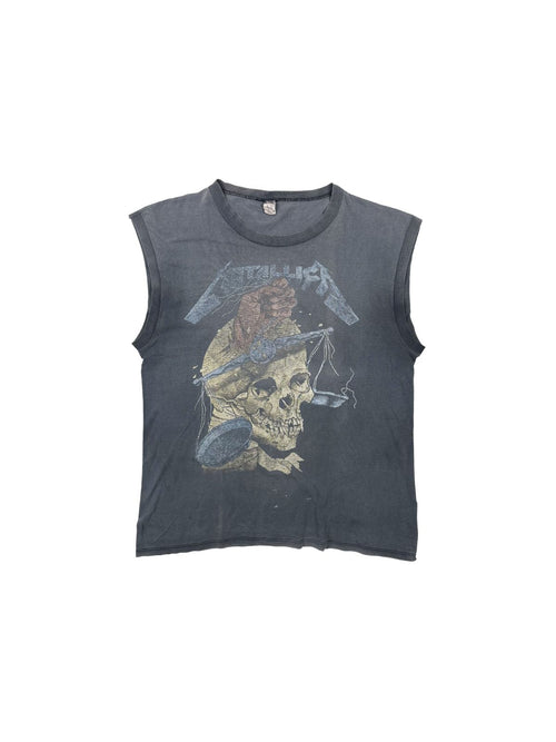 Vorderansicht eines extrem seltenen Metallica Vintage Tank Tops zum Album „...And Justice for All“ aus den späten 1980ern; zeigt den „Their Money Tips Her Scales Again“ Grafikprint mit Totenkopf auf stark sonnengebleichtem, anthrazitfarbenem Stoff.