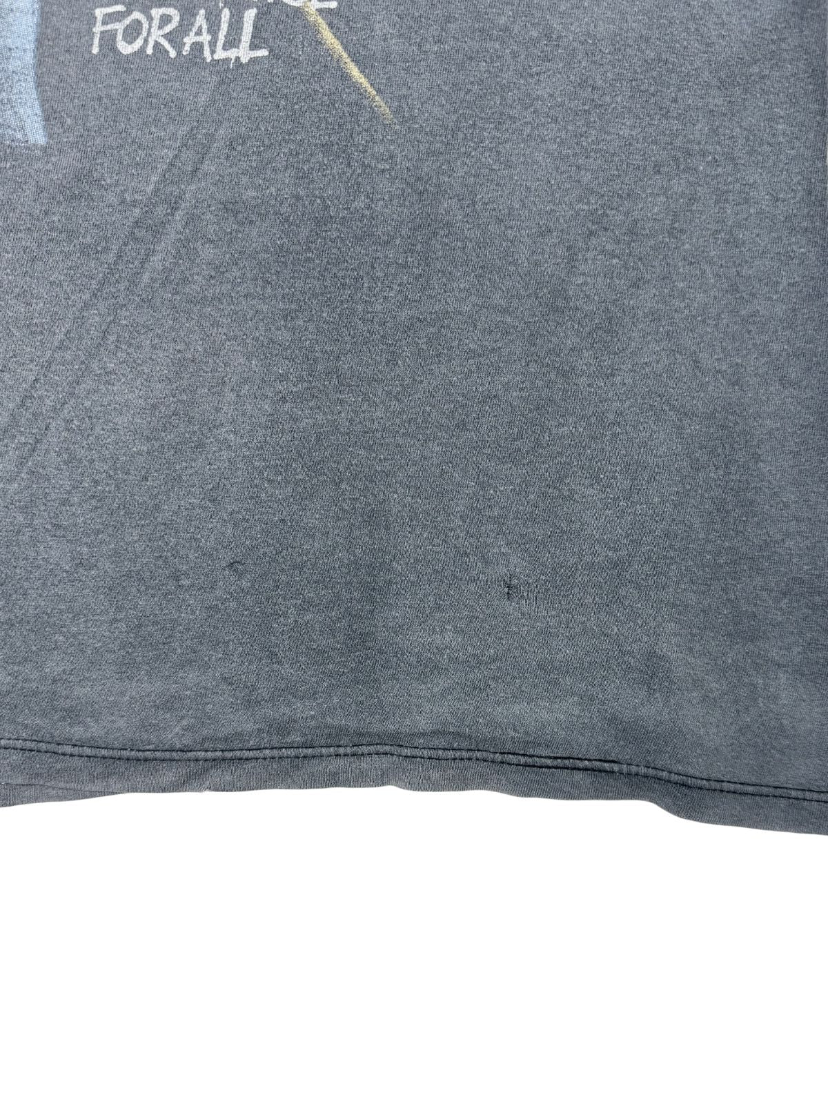 Nahaufnahme einer kleinen Reparaturstelle oder eines Lochs im unteren Rückenbereich des verwaschenen schwarzen Tank Tops.