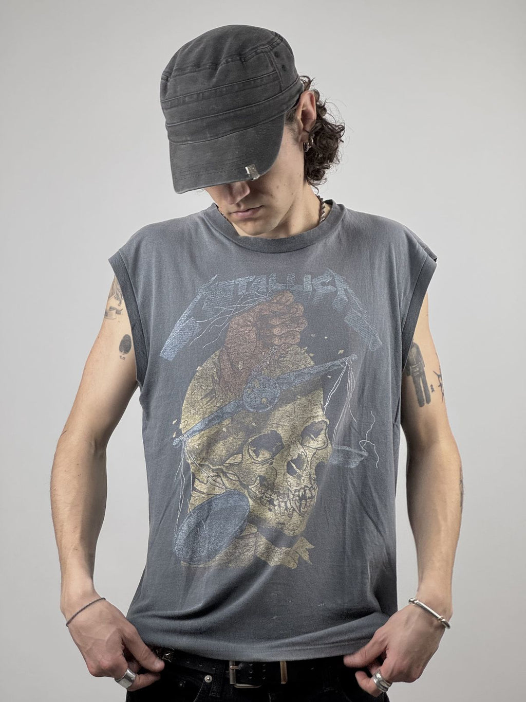 Ein Model trägt das sonnengebleichte Metallica Tank Top; zeigt die lockere Passform und das markante Thrash-Metal-Artwork im Streetwear-Style.