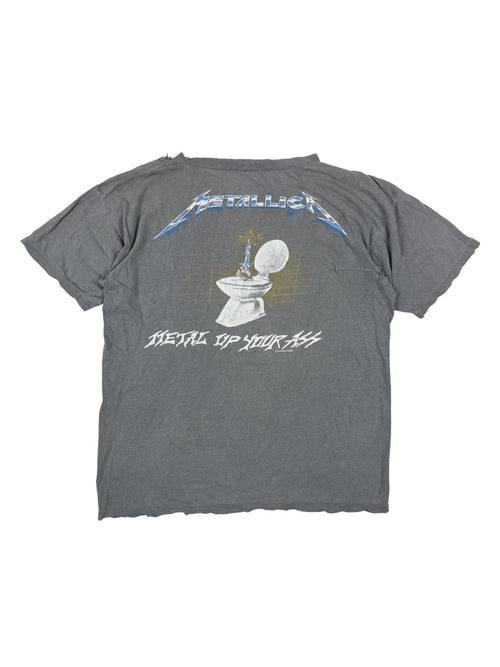 Rückseite des Metallica Vintage Shirts; zeigt die ikonische „Metal Up Your Ass“ Grafik mit dem Dolch aus der Toilette und dem blauen Metallica-Logo.