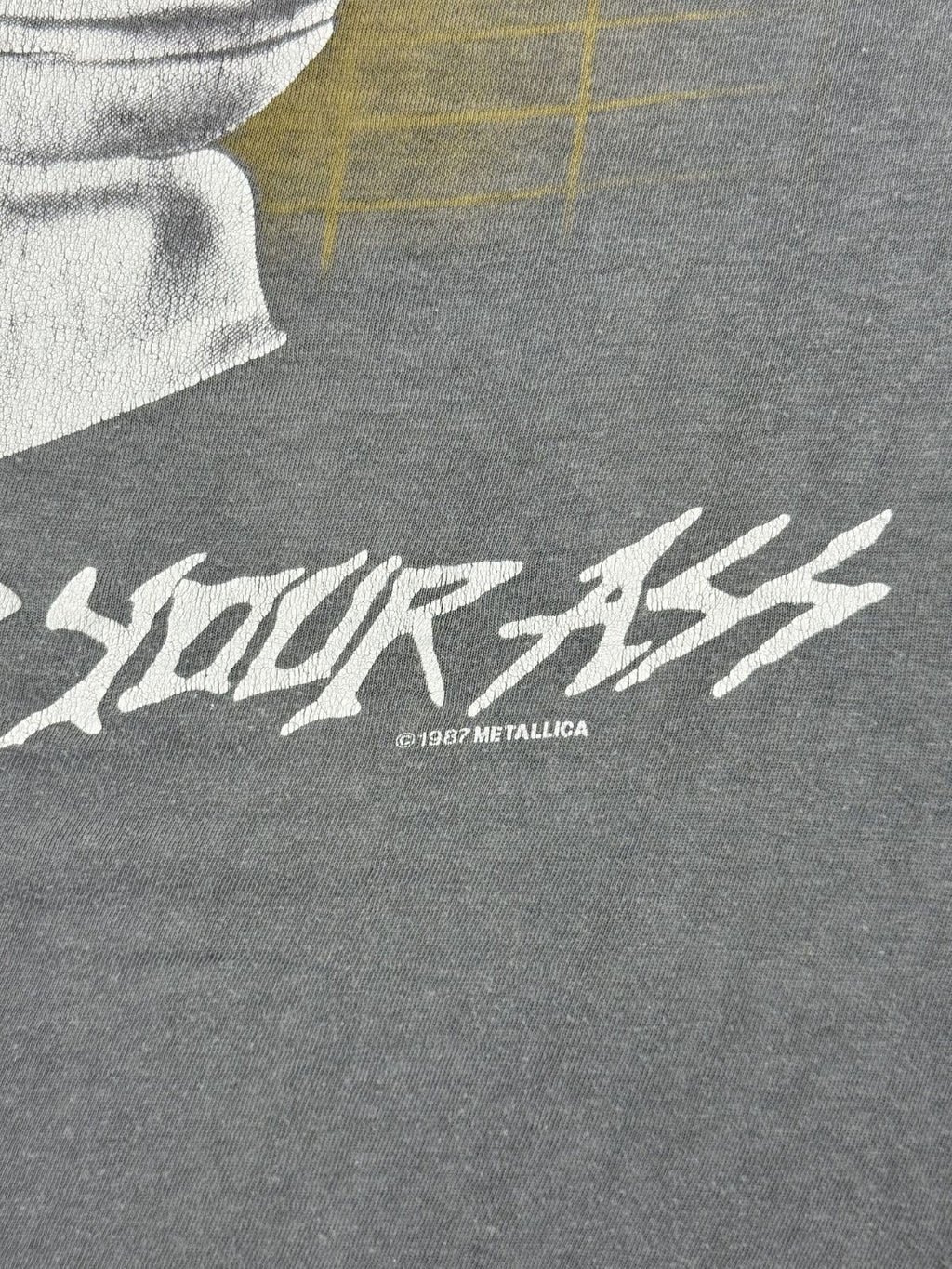 Mikro-Detail des Copyright-Prints unter der Rückengrafik: „© 1987 Metallica“ – ein entscheidendes Merkmal für die Altersbestimmung des Shirts.