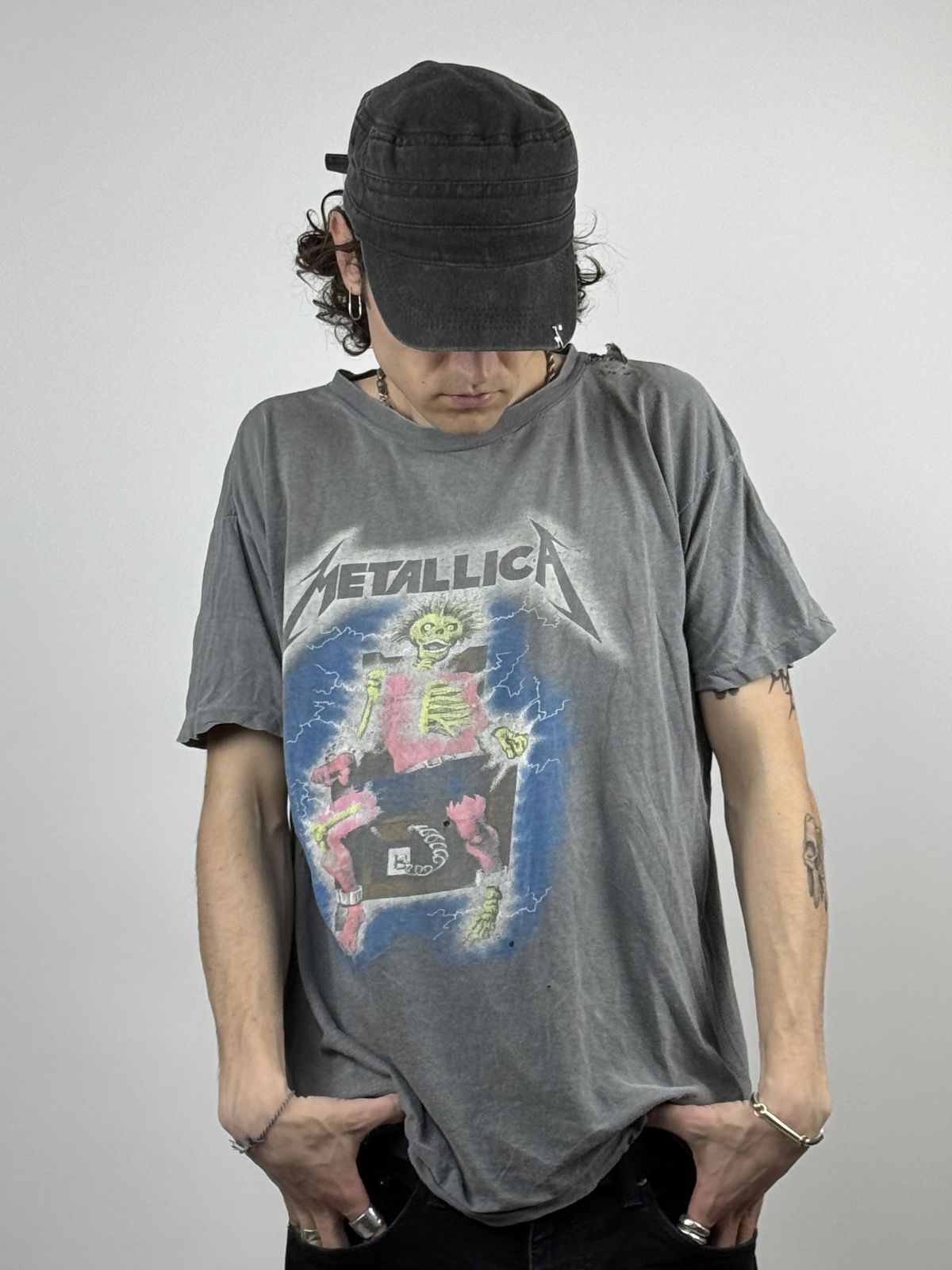 Person trägt das thrashed Metallica „Metal Up Your Ass“ Shirt; Fokus auf dem stark verwaschenen (faded) Stoff und dem authentischen Distressed-Look mit Löchern am Kragen.