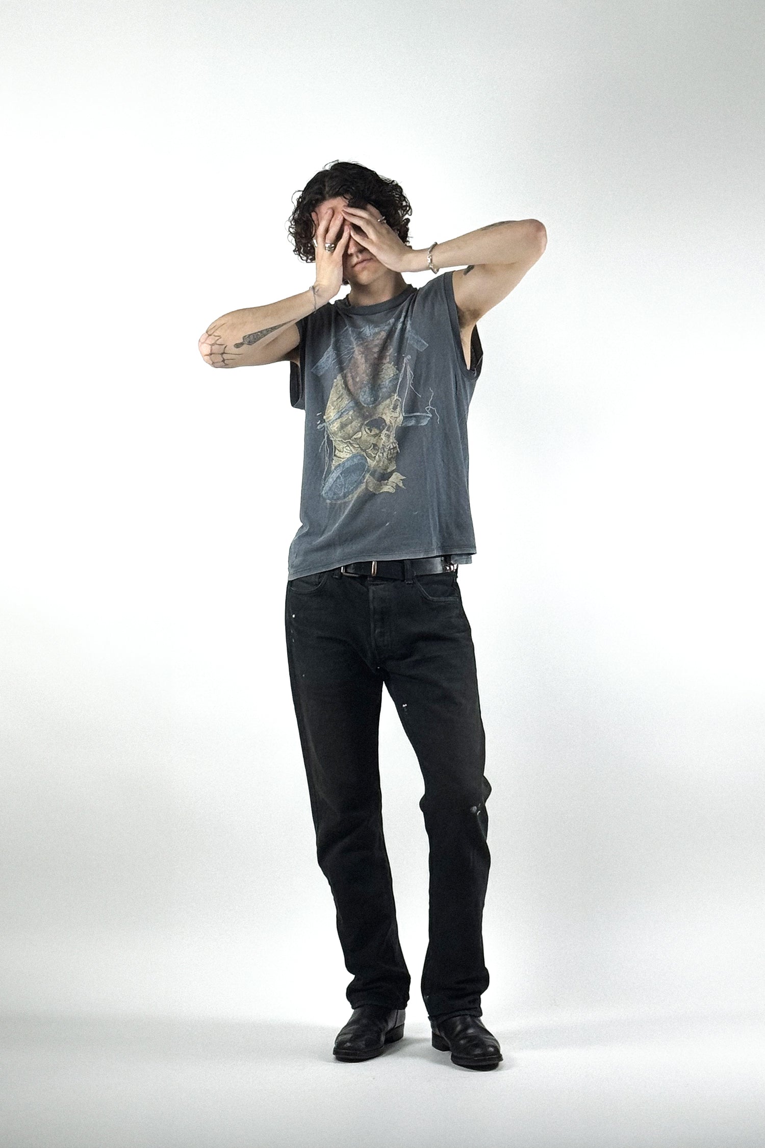 Ausgewaschenes Vintage Muskelshirt von Metallica mit verblichenem Totenkopf-Print von Pushead, kombiniert mit einer schwarzen Jeans im Grunge-Stil.