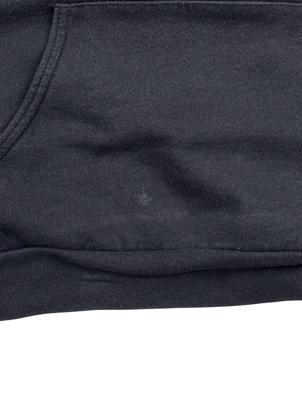 Detailaufnahme der Vorderseite direkt über dem elastischen Bund. Auf dem schwarzen Stoff neben der Kängurutasche ist ein kleiner, heller Fleck zu sehen.