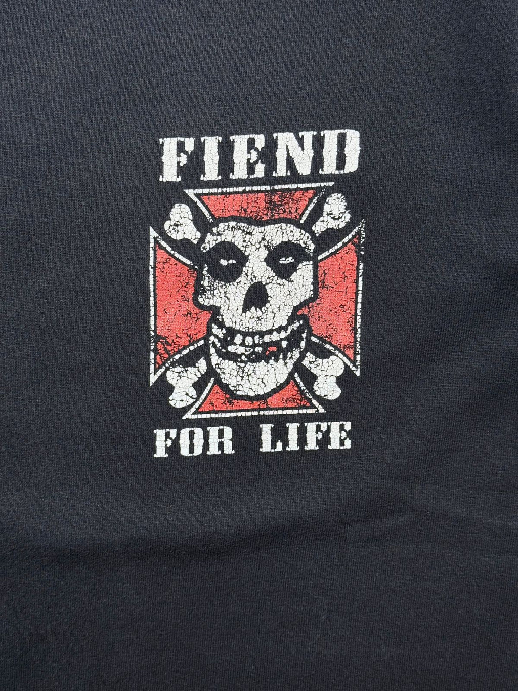 Nahaufnahme des linken Brustprints mit dem Schriftzug „FIEND FOR LIFE“ über dem Misfits-Schädel im eiseren Kreuz.