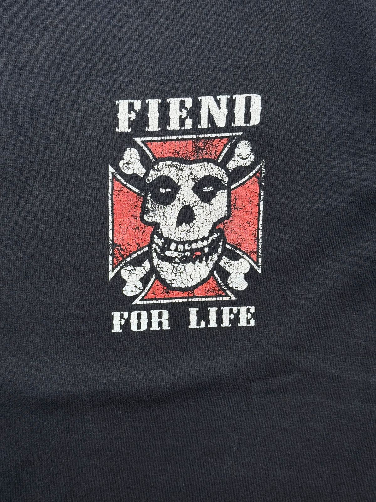 Nahaufnahme des linken Brustprints mit dem Schriftzug „FIEND FOR LIFE“ über dem Misfits-Schädel im eiseren Kreuz.