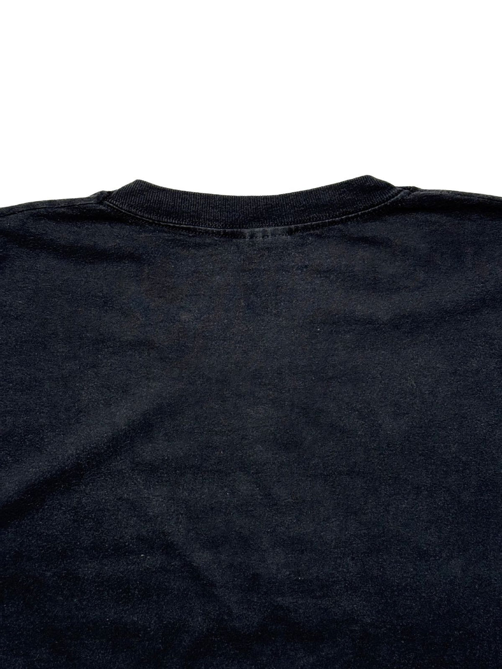 Detailaufnahme der oberen Rückseite mit Fokus auf das elastische Nackenbündchen und die feine Baumwollstruktur des schwarzen Stoffes.