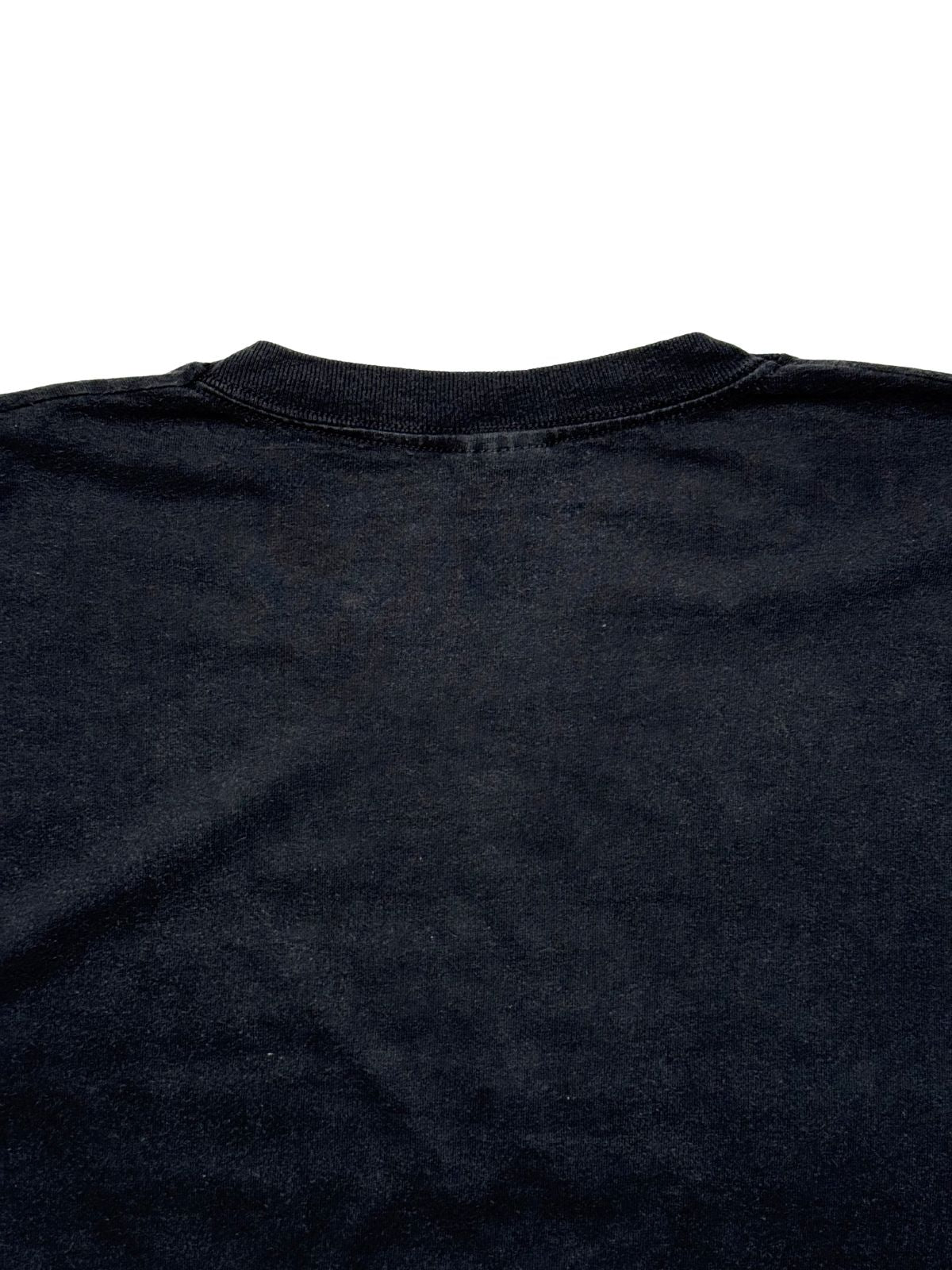 Detailaufnahme der oberen Rückseite mit Fokus auf das elastische Nackenbündchen und die feine Baumwollstruktur des schwarzen Stoffes.