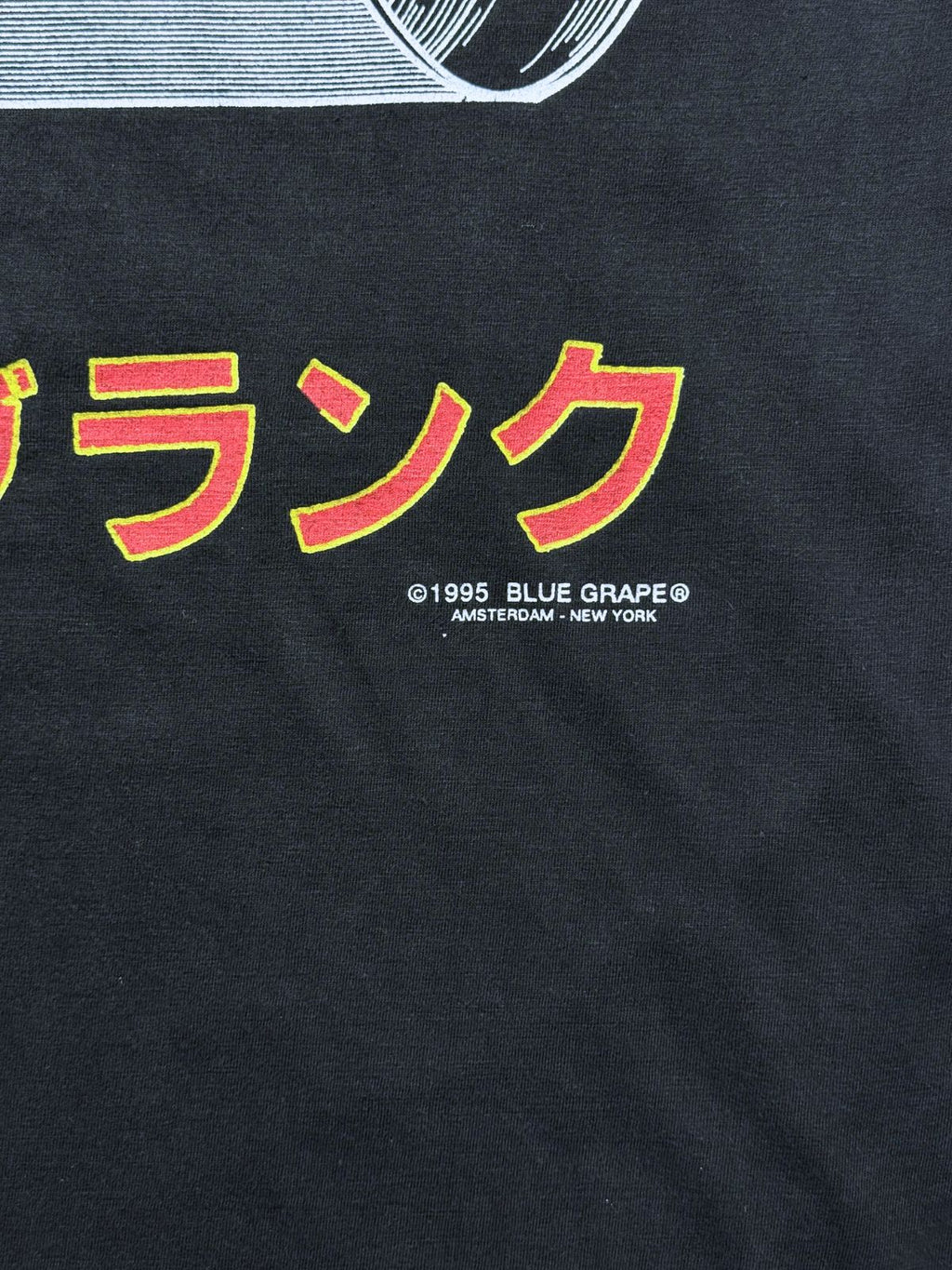 Makroaufnahme des hinteren Copyright-Vermerks unter den japanischen Schriftzeichen: „©1995 BLUE GRAPE® AMSTERDAM - NEW YORK“.