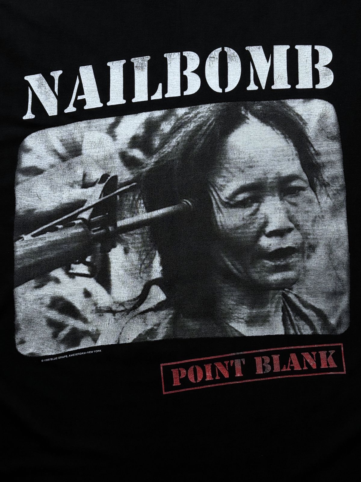 Nahaufnahme des vorderen Album-Cover-Prints zum Nailbomb-Debütalbum „Point Blank“ mit „NAILBOMB“-Schriftzug im Stencil-Look.