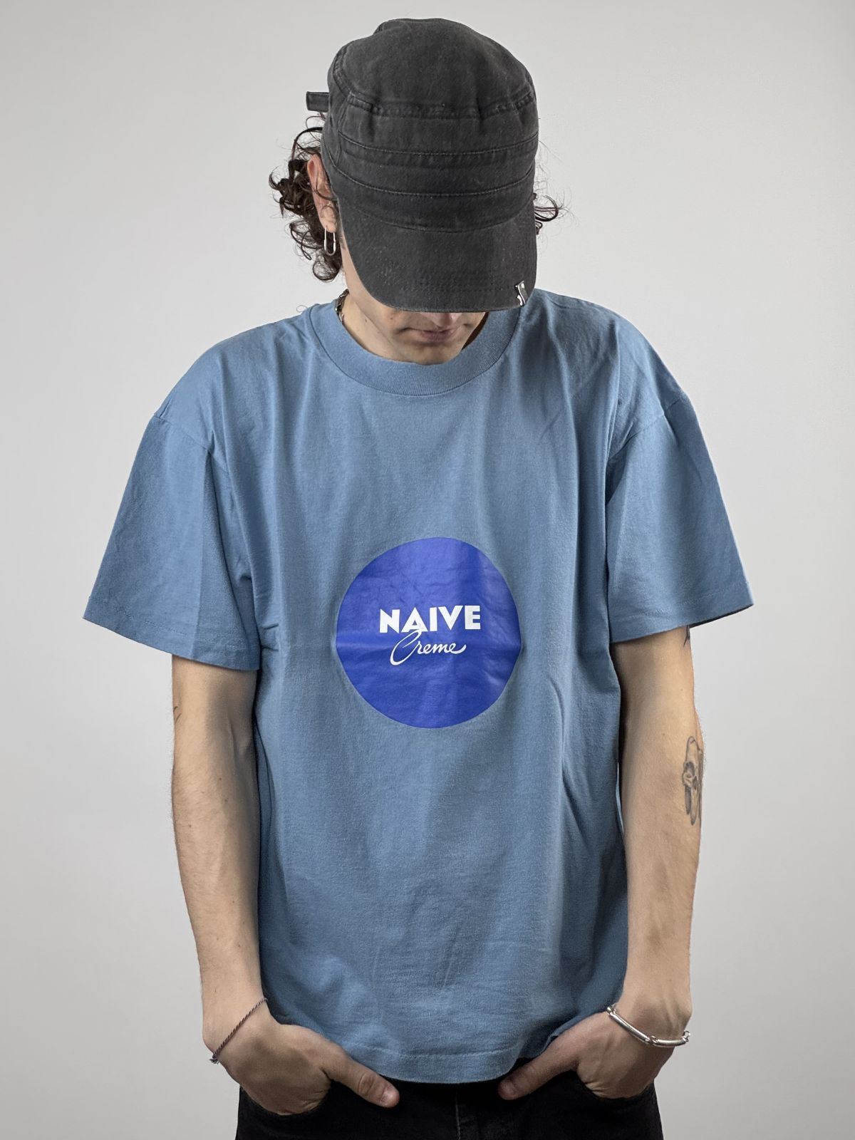 Frontale Ansicht des Modells mit dem hellblauen Bootleg-Shirt; zeigt die Platzierung des Logos und die authentische Vintage-Farbe.