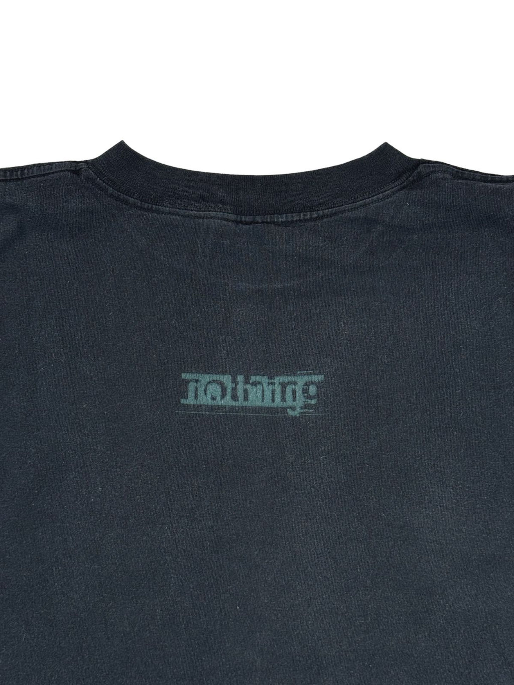 Nahaufnahme der oberen Rückseite des Shirts mit Fokus auf den Halsausschnitt und das darunter platzierte „nothing“-Plattenlabel-Logo.