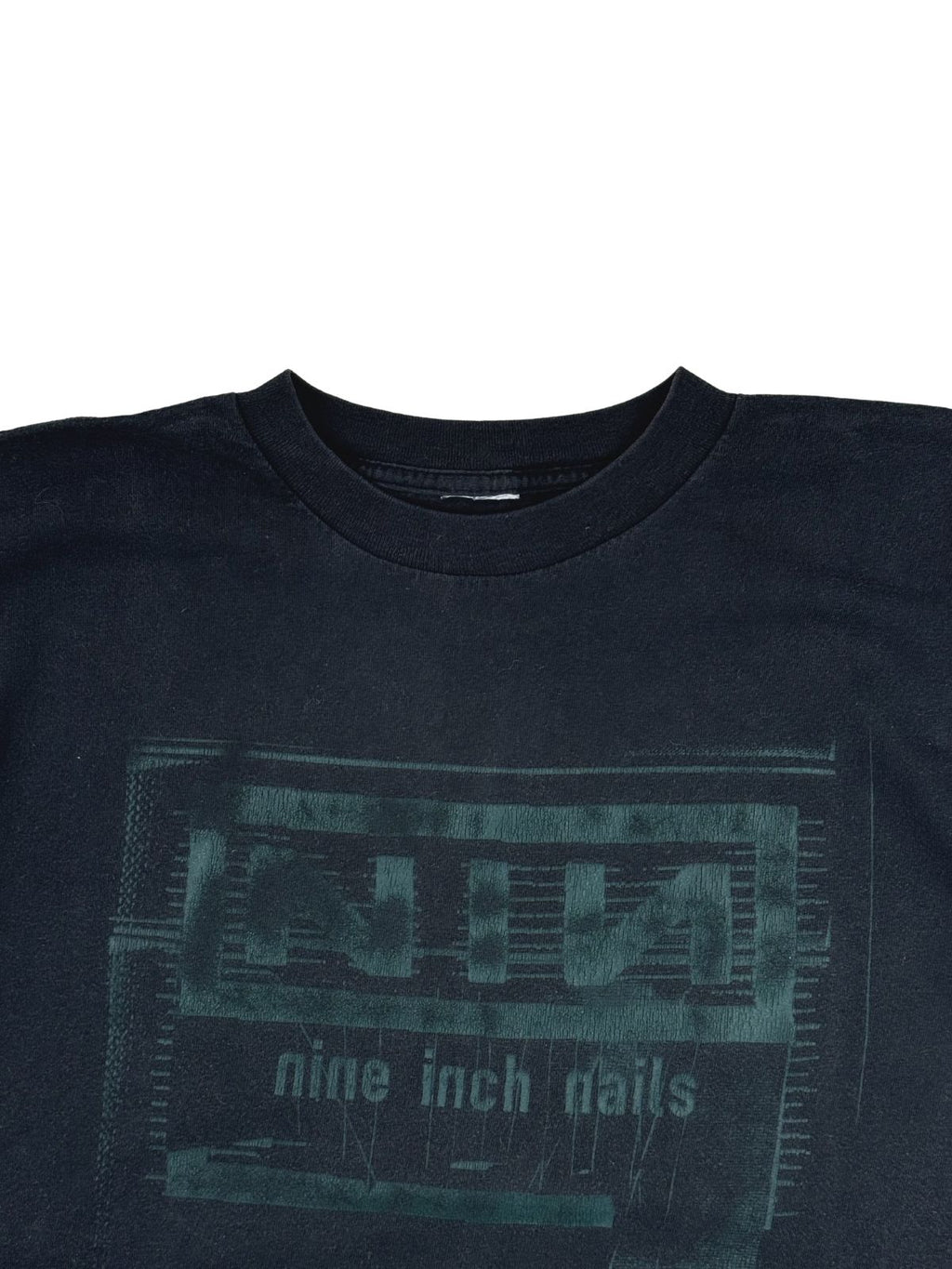 Detailansicht des Rundhalsausschnitts auf der Vorderseite mit Blick auf das verblasste, grüne „NIN nine inch nails“ Box-Logo-Artwork.