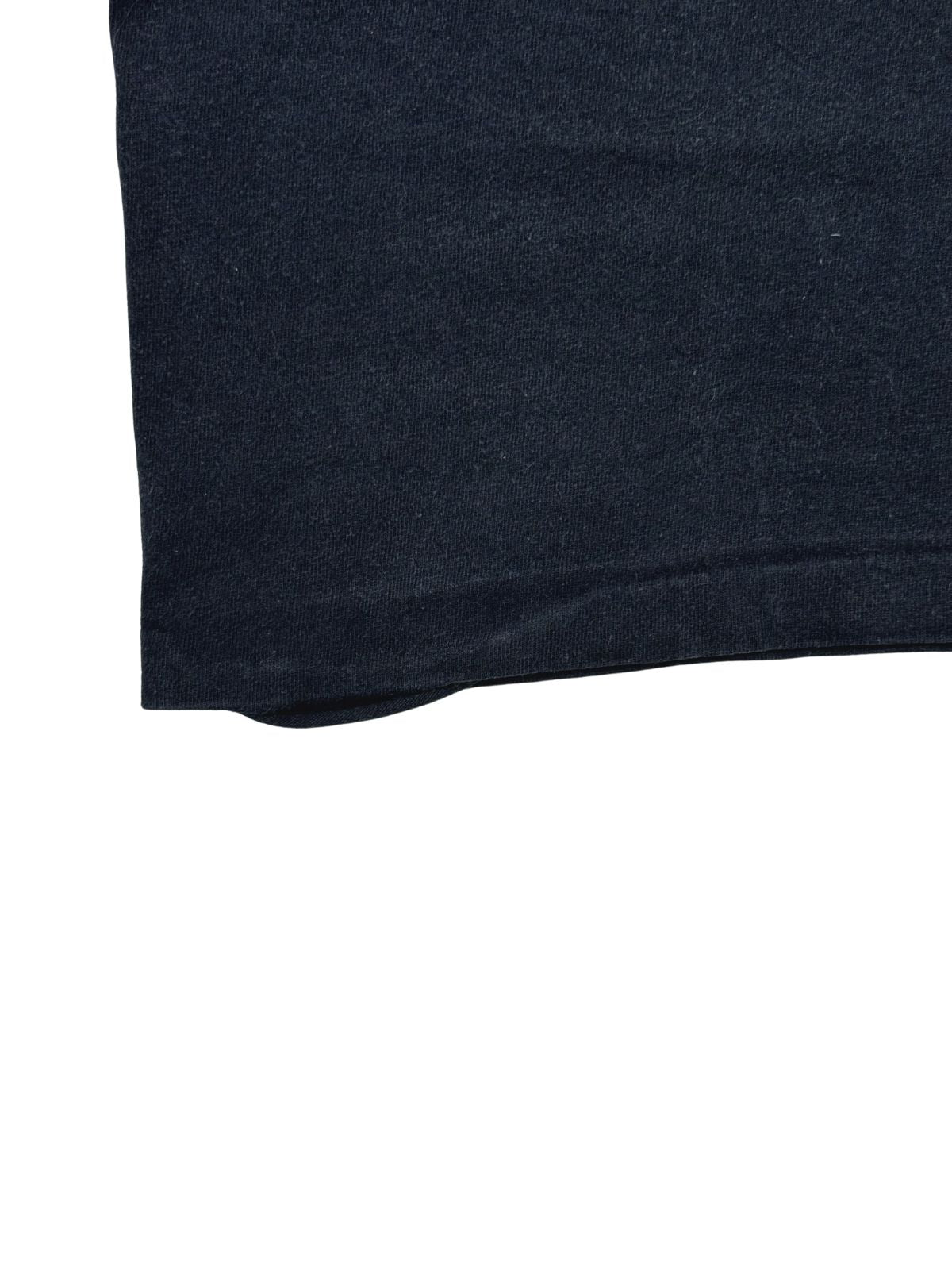 Detailaufnahme der Saumecke auf der Unterseite des Shirts, die den getragenen Vintage-Zustand des Saums zeigt.