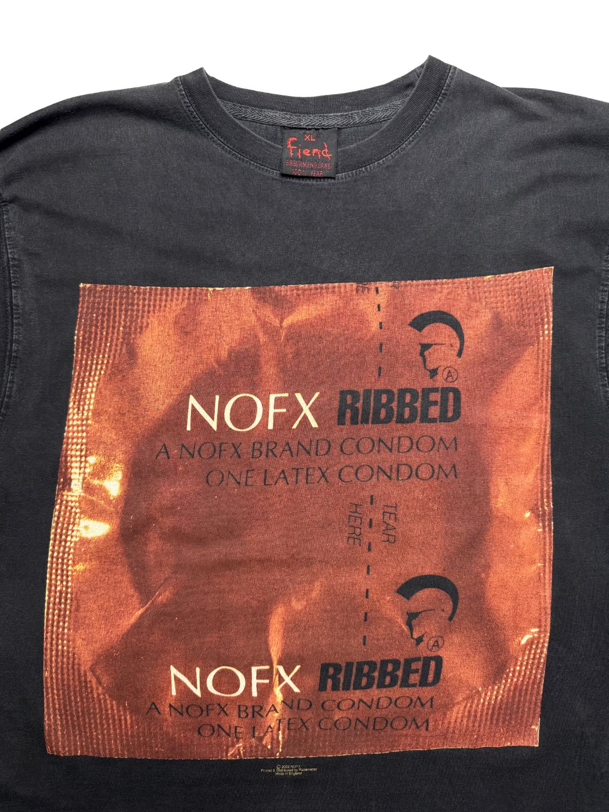 Nahaufnahme der vorderen Brustpartie mit Blick auf den gerippten Rundhalsausschnitt, das schwarze „Fiend“-Nackenetikett und den „NOFX RIBBED“-Druck.