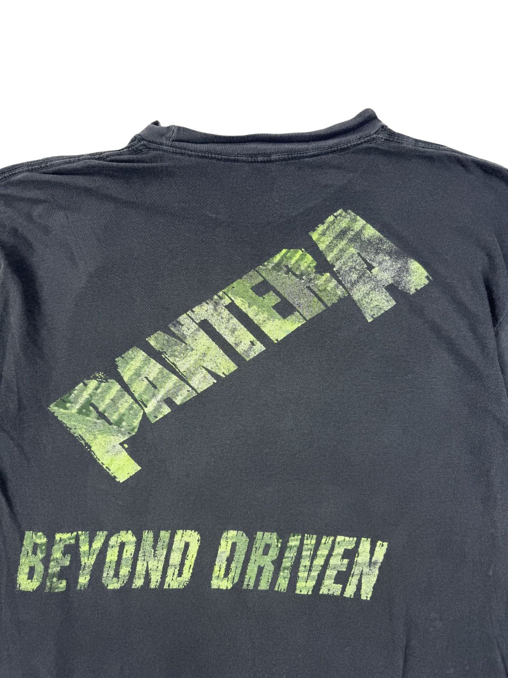 Nahaufnahme der oberen Rückseite mit Fokus auf die distressed Grafik-Prints „PANTERA BEYOND DRIVEN“ auf dem grauen Baumwollstoff.