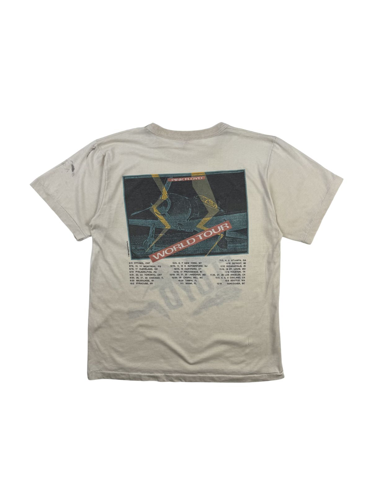 Rückseite des weißen 1987er Pink Floyd Tour-Shirts mit einem großen, quadratischen Grafikprint eines Propellerflugzeugs und den darunter gedruckten US-Tourdaten.
