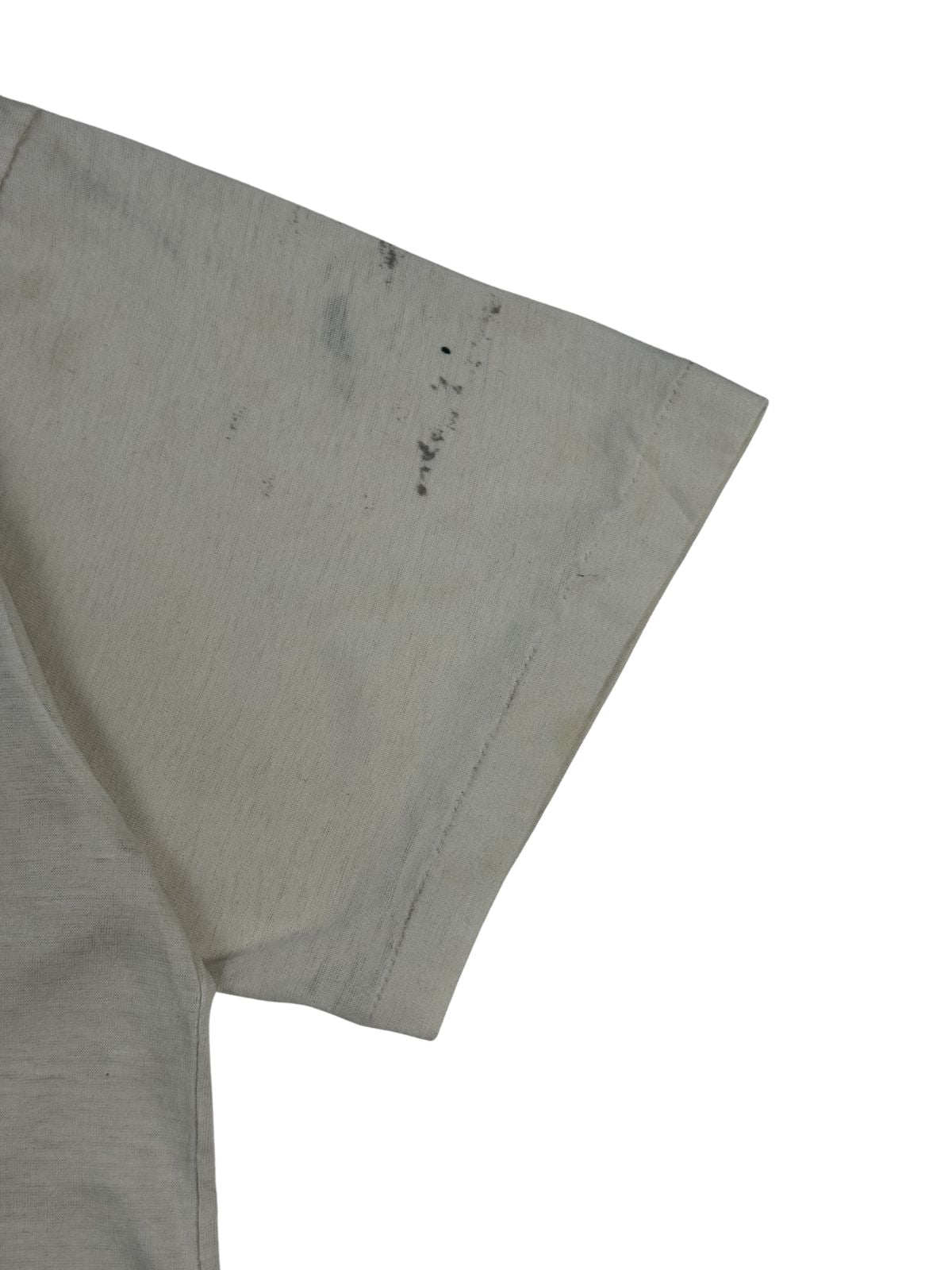 Detailaufnahme des linken Ärmelbunds mit Single-Stitch-Verarbeitung (Einfachnaht) und kleinen, authentischen Tinten- oder Schmutzflecken auf dem alten Baumwollstoff.