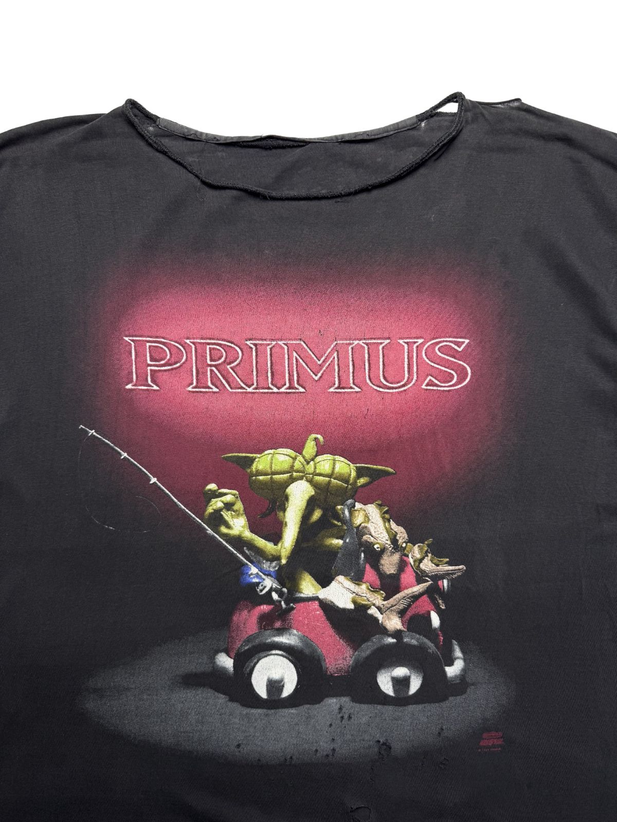 Detailansicht des vorderen Siebdrucks mit dem „PRIMUS“-Schriftzug und der bizarren Knetfigur im roten Auto.