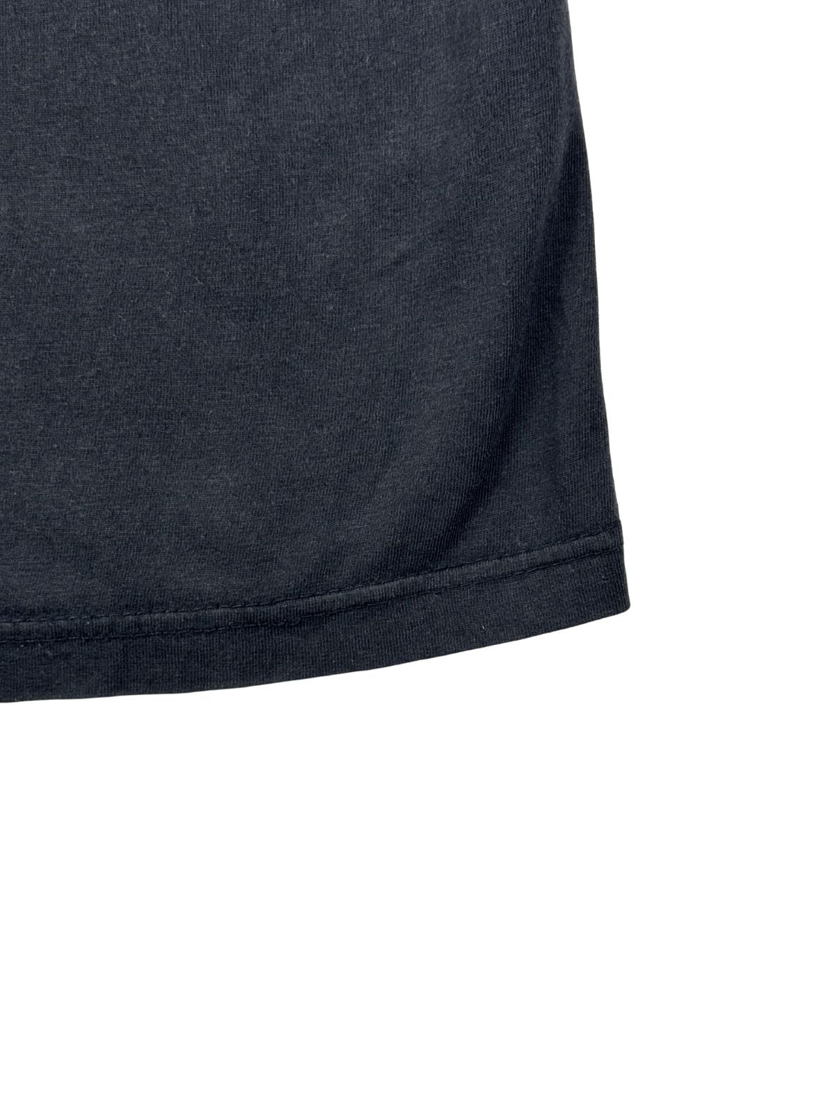 Nahaufnahme einer intakten Doppelnaht am Saum des verwaschenen, schwarzen Primus Band-Shirts.